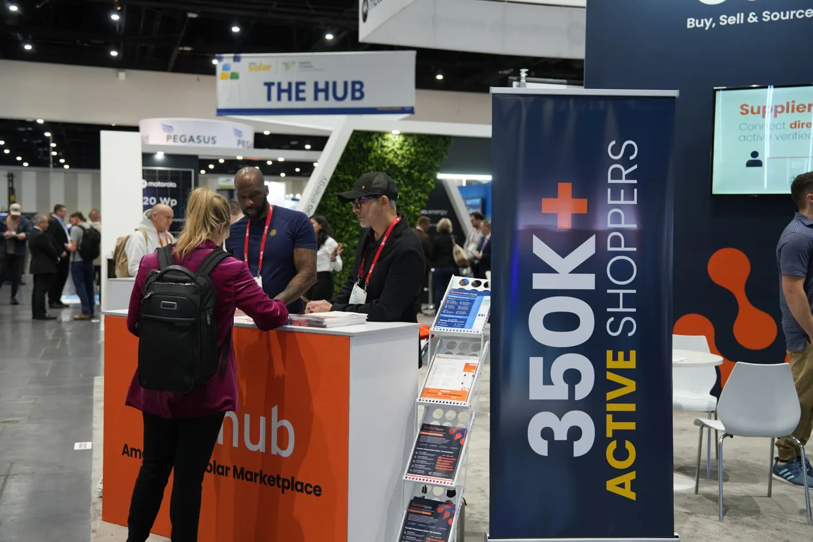 Sunhub staff greeting a visitor at the booth counter