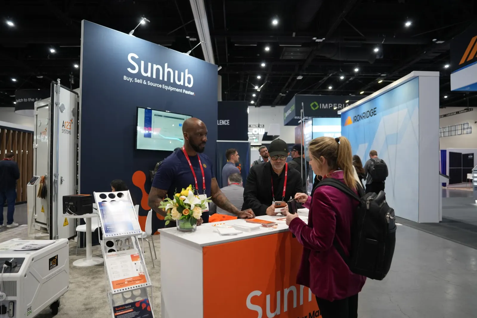 Visitor reviewing Sunhub literature at the booth counter