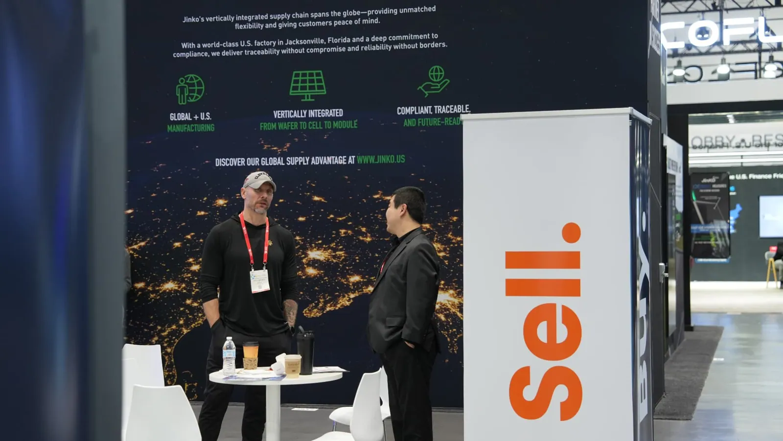 Conversation beside the Sell banner at the Sunhub booth