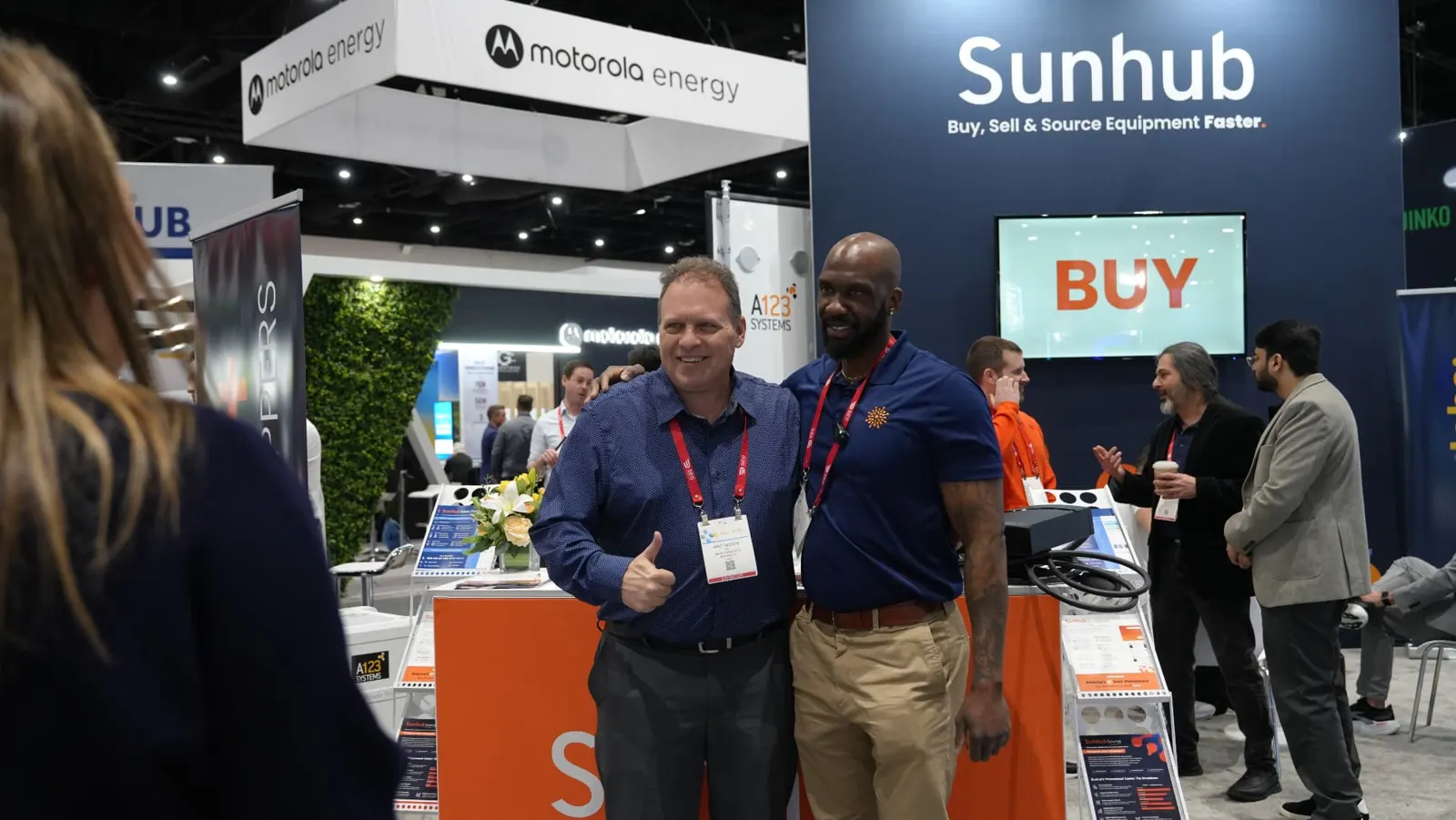 Sunhub team member and a buyer at the booth counter under the Sunhub sign